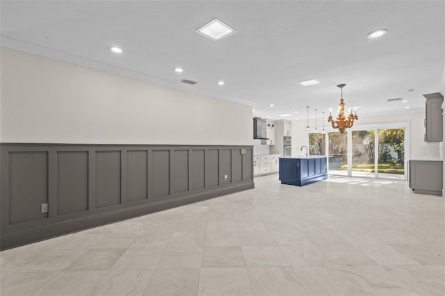 empty room with crown molding, sink, and a notable chandelier