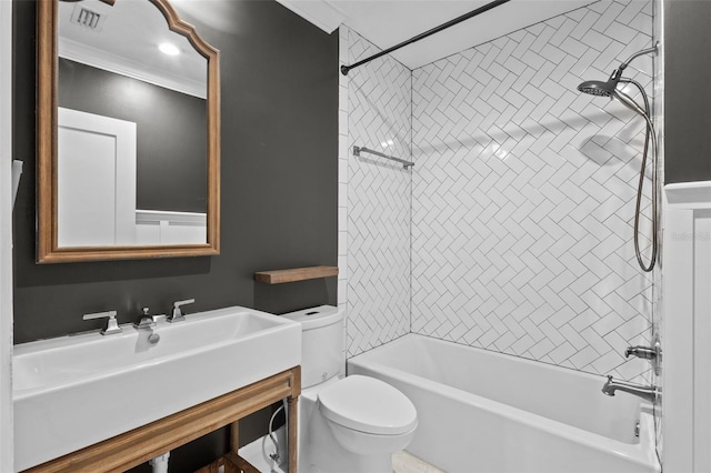 full bathroom featuring ornamental molding, toilet, tiled shower / bath combo, and sink