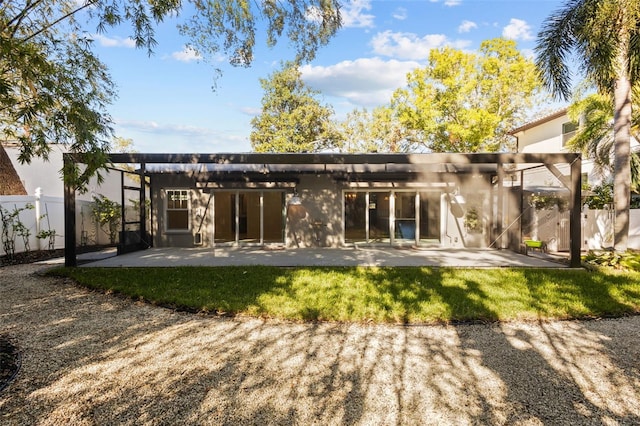 back of house featuring a pergola, a lawn, and a patio