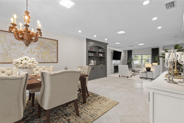 dining room featuring a premium fireplace, visible vents, a notable chandelier, and recessed lighting