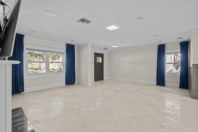 empty room with visible vents, crown molding, and baseboards