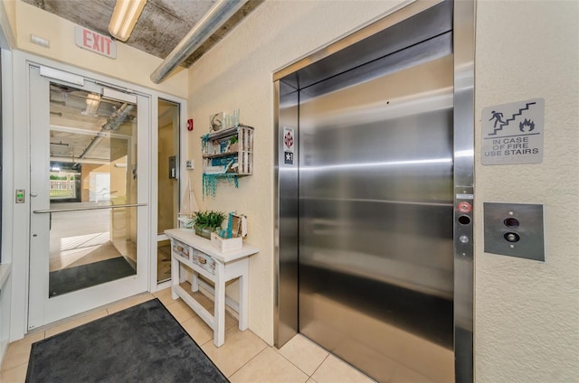 interior space featuring elevator and light tile patterned floors