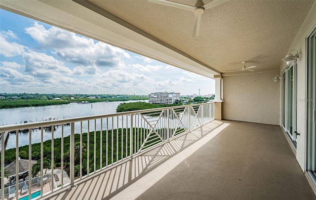 balcony featuring ceiling fan and a water view