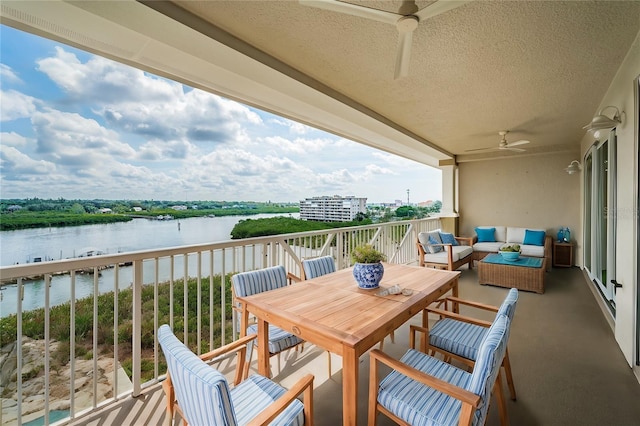 balcony with outdoor lounge area, a water view, and ceiling fan