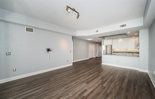 unfurnished living room with a textured ceiling, sink, and dark hardwood / wood-style floors