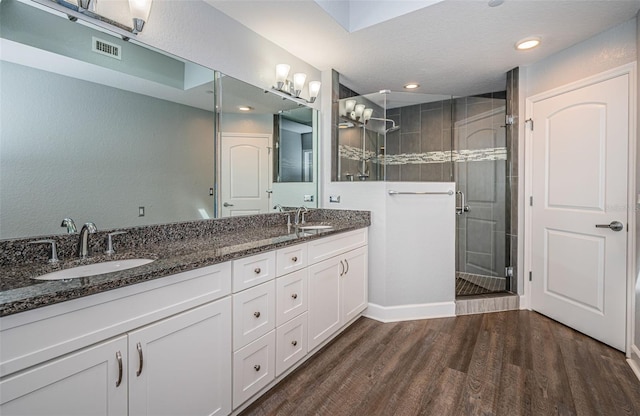 bathroom featuring hardwood / wood-style flooring, vanity, and walk in shower