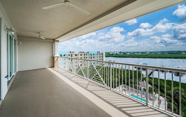 balcony featuring ceiling fan and a water view