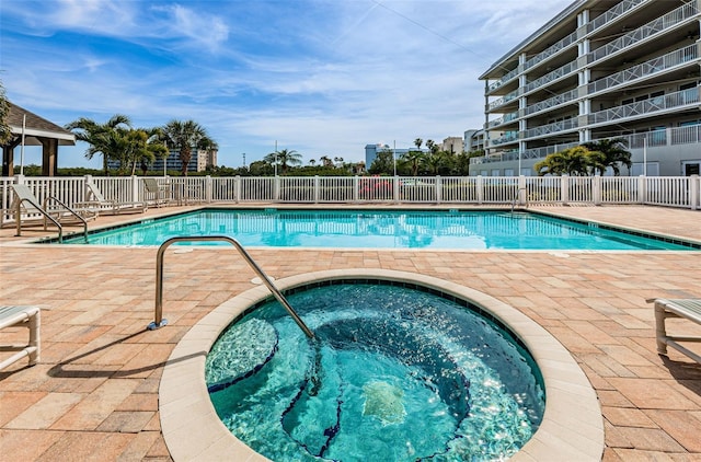 view of swimming pool featuring a community hot tub and a patio