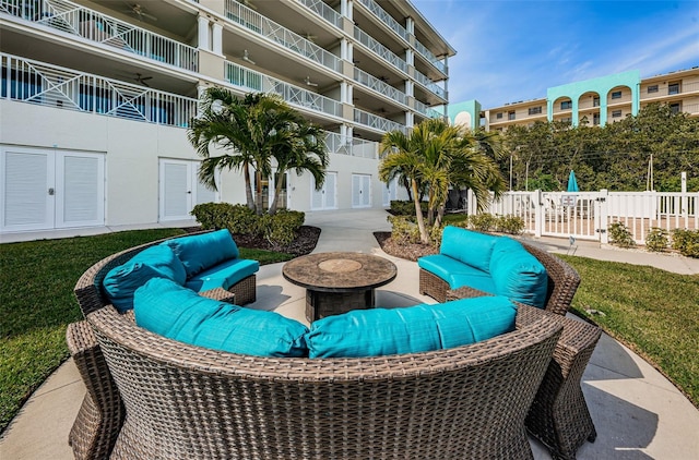 view of patio with an outdoor living space with a fire pit