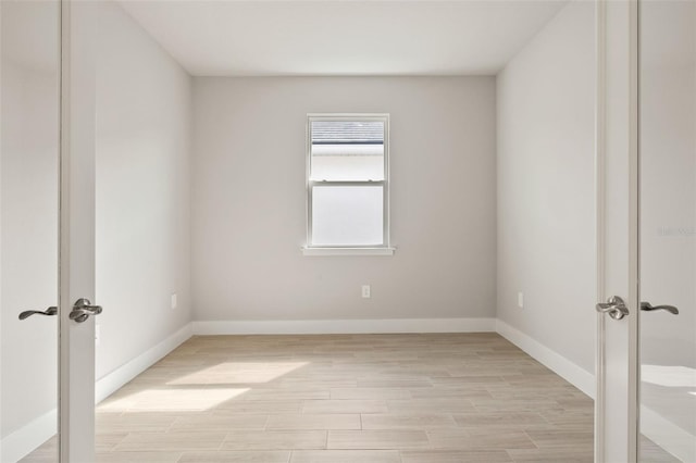 spare room featuring light hardwood / wood-style floors and french doors