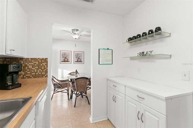 2232 Greenwich Dr Unit 56, Sun City Center, FL 33573 - kitchen with tasteful backsplash, white cabinets, a sink, light countertops, and light tile patterned flooring