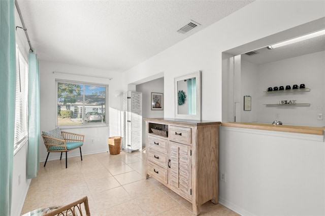 2232 Greenwich Dr Unit 56, Sun City Center, FL 33573 - hall with baseboards, visible vents, light tile patterned floors, and a textured ceiling