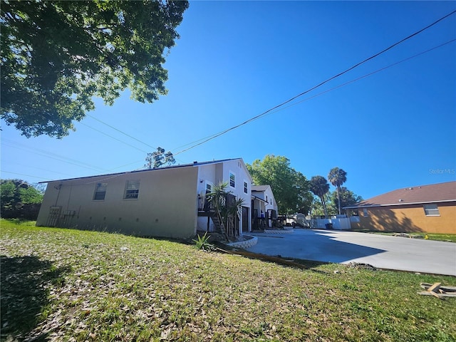 5802 Mohr Loop Unit 5802-5804-5806-5808, Tampa, FL 33615 - back of house with stucco siding and a lawn