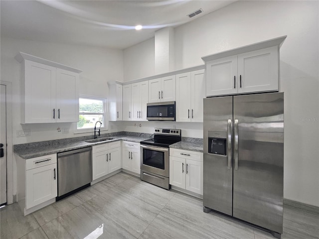 5802 Mohr Loop Unit 5802-5804-5806-5808, Tampa, FL 33615 - kitchen with stainless steel appliances, a sink, white cabinets, high vaulted ceiling, and dark stone countertops