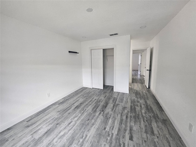 5802 Mohr Loop Unit 5802-5804-5806-5808, Tampa, FL 33615 - unfurnished bedroom featuring dark wood-style floors, baseboards, a closet, and a textured ceiling