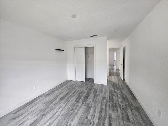 5802 Mohr Loop Unit 5802-5804-5806-5808, Tampa, FL 33615 - unfurnished bedroom featuring dark wood-style flooring, baseboards, a textured ceiling, and a closet