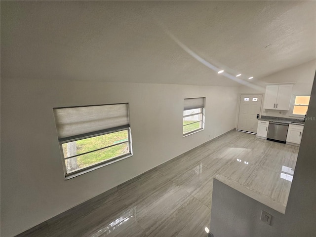 5802 Mohr Loop Unit 5802-5804-5806-5808, Tampa, FL 33615 - unfurnished living room with vaulted ceiling and a textured ceiling