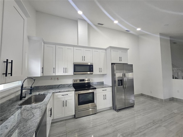 5802 Mohr Loop Unit 5802-5804-5806-5808, Tampa, FL 33615 - kitchen with stainless steel appliances, a sink, light stone counters, high vaulted ceiling, and white cabinets