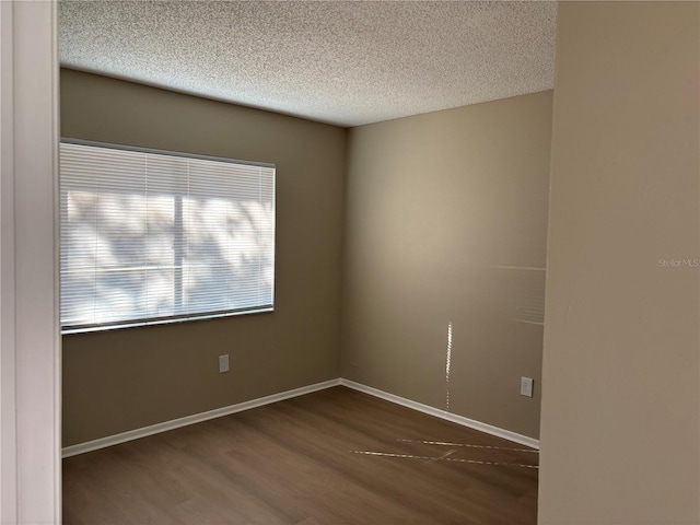 unfurnished room featuring a textured ceiling and dark wood-type flooring