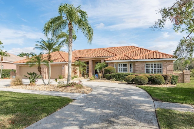 mediterranean / spanish house featuring a front yard and a garage