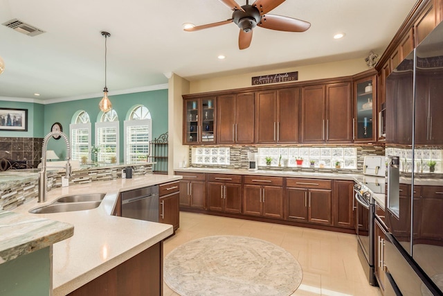 kitchen featuring tasteful backsplash, ornamental molding, stainless steel appliances, sink, and hanging light fixtures