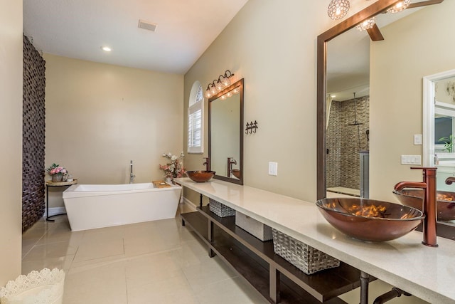 full bathroom with a freestanding tub, visible vents, a sink, and tile patterned floors