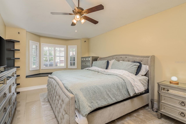 bedroom with light tile patterned floors, baseboards, and a ceiling fan