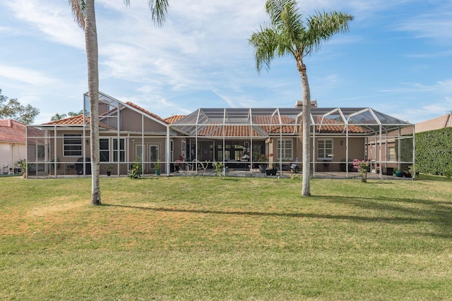 back of house with a lanai, a lawn, and a tiled roof