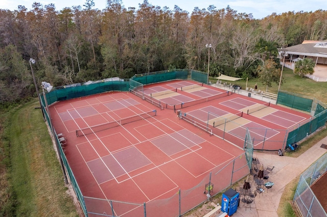 view of sport court featuring a wooded view