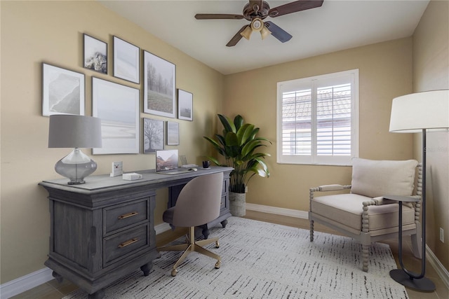 office space featuring ceiling fan and baseboards