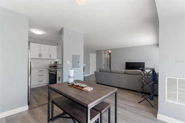 dining space featuring light hardwood / wood-style floors and electric panel