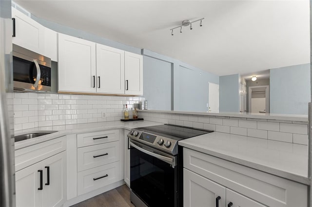 kitchen with white cabinets, backsplash, stainless steel appliances, and dark hardwood / wood-style floors