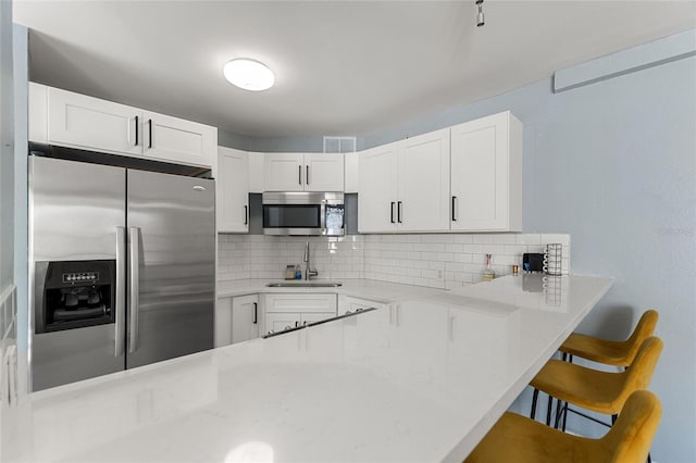 3315 58th Ave S Unit 210, Saint Petersburg, FL 33712 - kitchen with appliances with stainless steel finishes, a sink, decorative backsplash, and light countertops