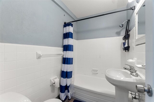 bathroom featuring shower / tub combo with curtain, tile walls, and toilet