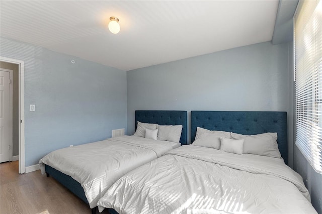 3315 58th Ave S Unit 210, Saint Petersburg, FL 33712 - bedroom featuring wood finished floors, multiple windows, and baseboards