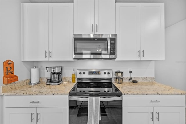 kitchen with light stone counters, white cabinets, and appliances with stainless steel finishes