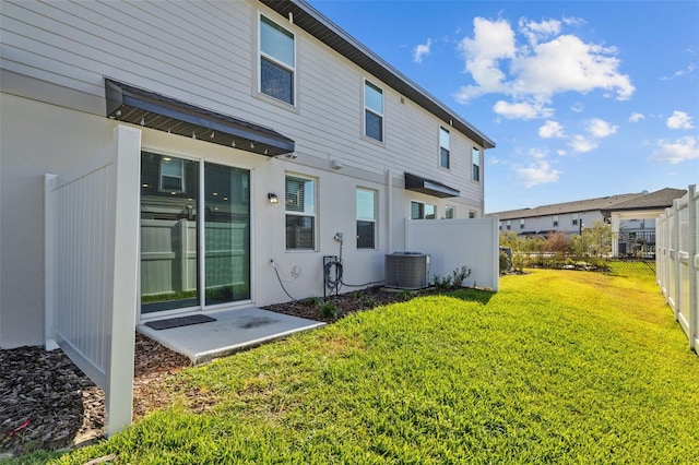 rear view of house with a lawn and central air condition unit