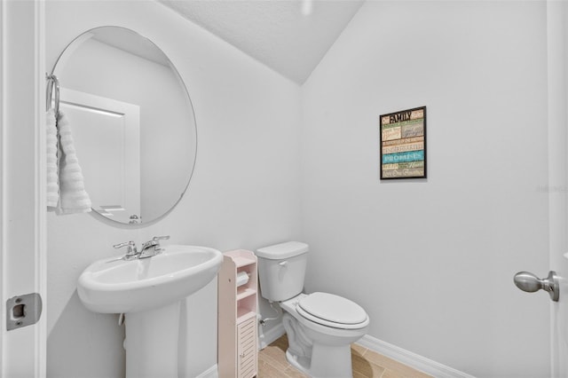 bathroom with toilet, hardwood / wood-style floors, and vaulted ceiling