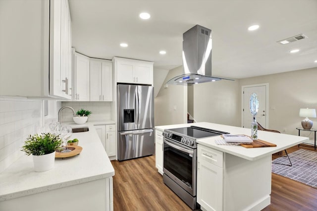 kitchen with white cabinetry, island range hood, a kitchen island, and appliances with stainless steel finishes