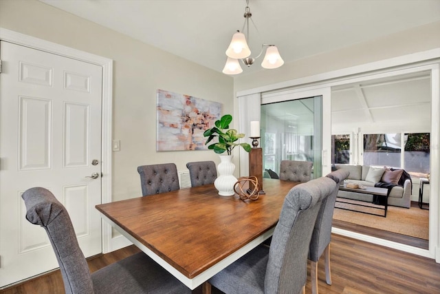 dining area featuring an inviting chandelier and dark wood-type flooring