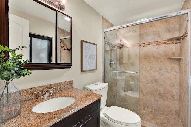 bathroom featuring vanity, an enclosed shower, and toilet