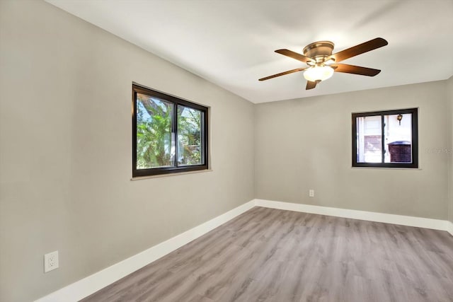 spare room featuring light hardwood / wood-style floors, a wealth of natural light, and ceiling fan