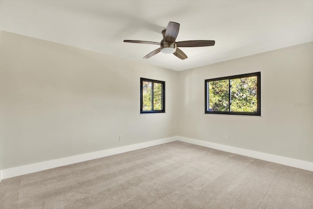 carpeted spare room with ceiling fan and a wealth of natural light