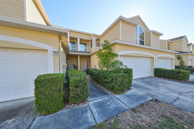 townhome / multi-family property featuring a balcony and a garage