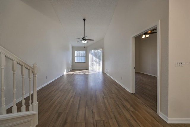 unfurnished living room featuring a textured ceiling, ceiling fan, dark wood-type flooring, and vaulted ceiling