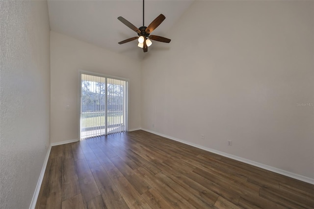 spare room with a towering ceiling, dark hardwood / wood-style floors, and ceiling fan