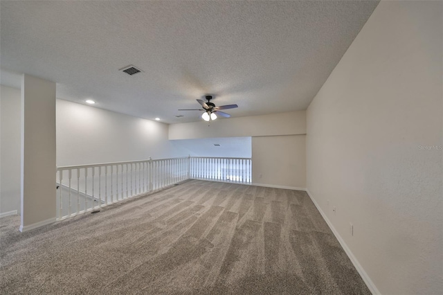 carpeted empty room with a textured ceiling and ceiling fan