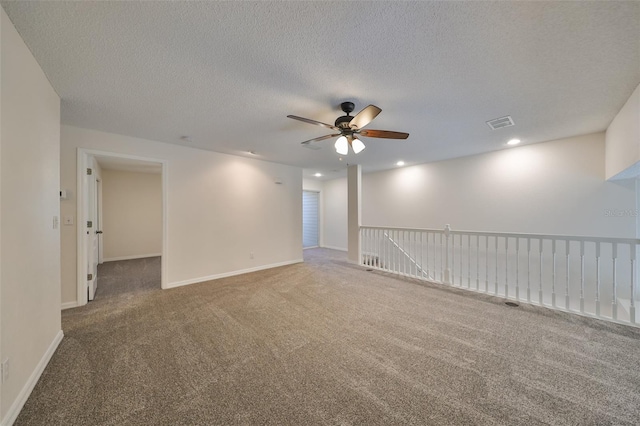 carpeted spare room with ceiling fan and a textured ceiling