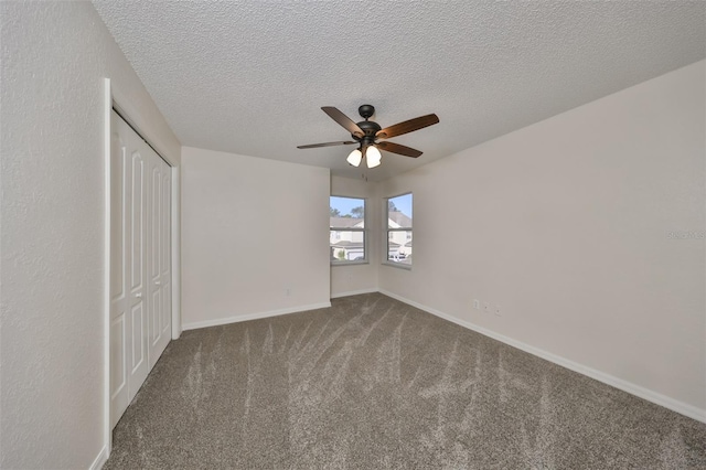 unfurnished bedroom with carpet flooring, ceiling fan, a textured ceiling, and a closet