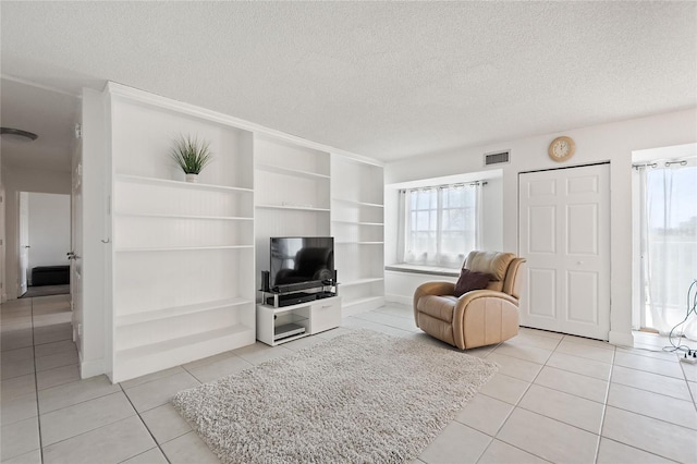 tiled living room with built in shelves and a textured ceiling